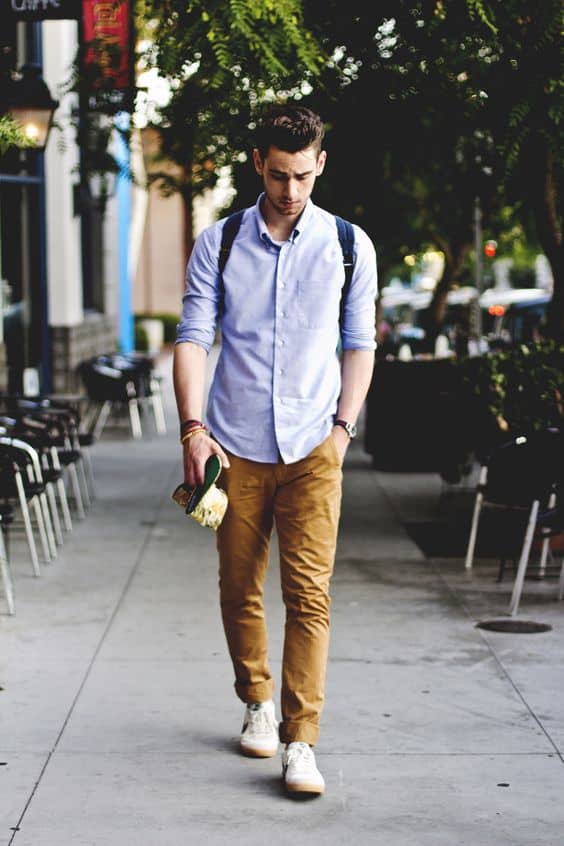 ocher trousers, a blue shirt and white sneakers are a perfect early fall outfit